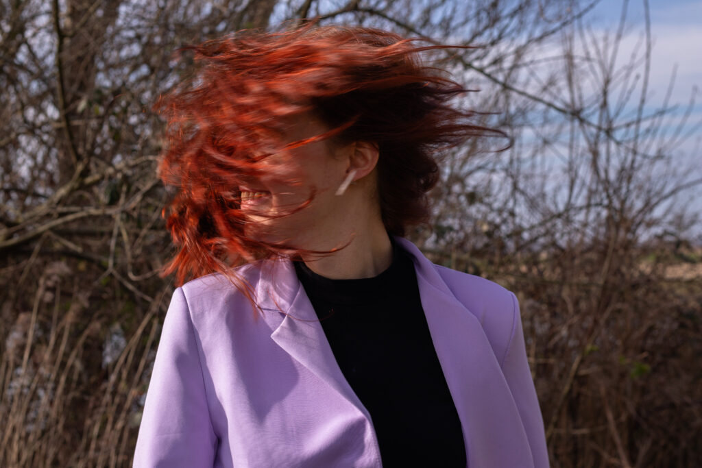 Vrouw schudt haar haren tijdens een creatieve brandingshoot.
