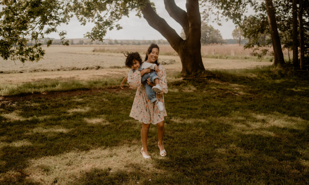 Moeder en zoon in een weiland tijdens motherhoodshoot