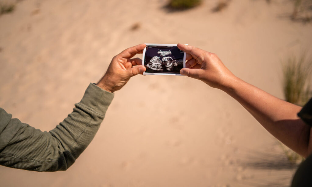 Pregnancyshoot waarbij de toekomstige ouders een echofoto vasthouden.