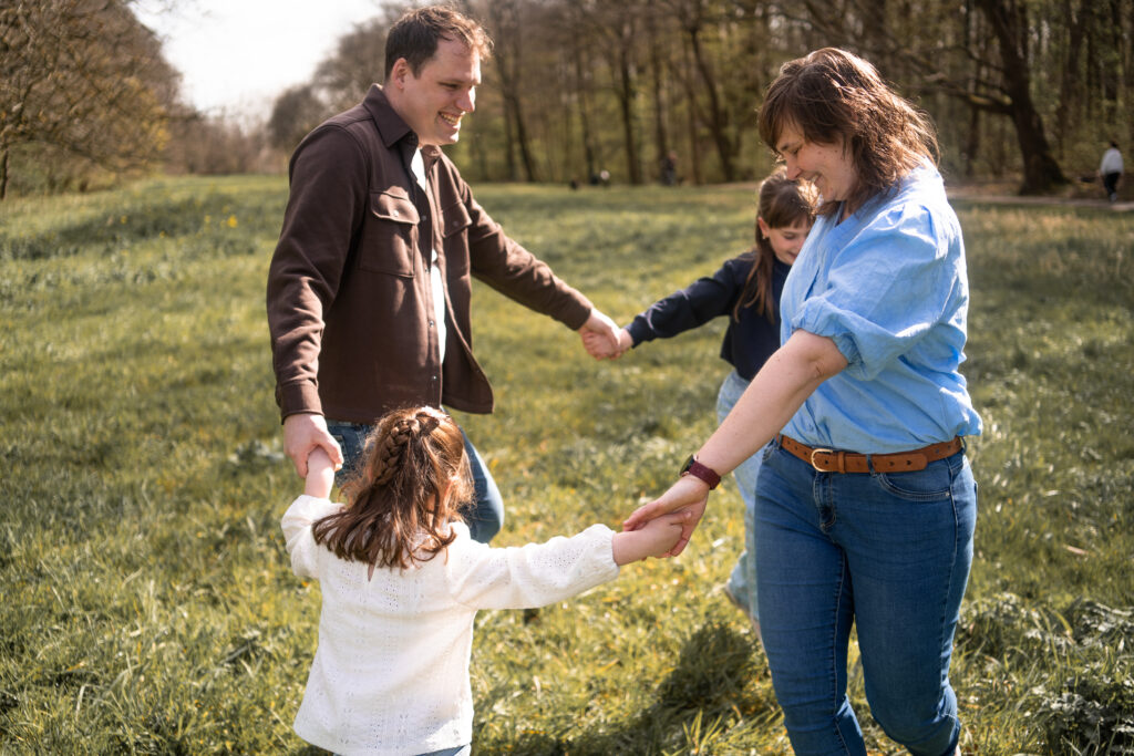 Gezin danst en heeft plezier tijdens een ontspannen familyshoot.